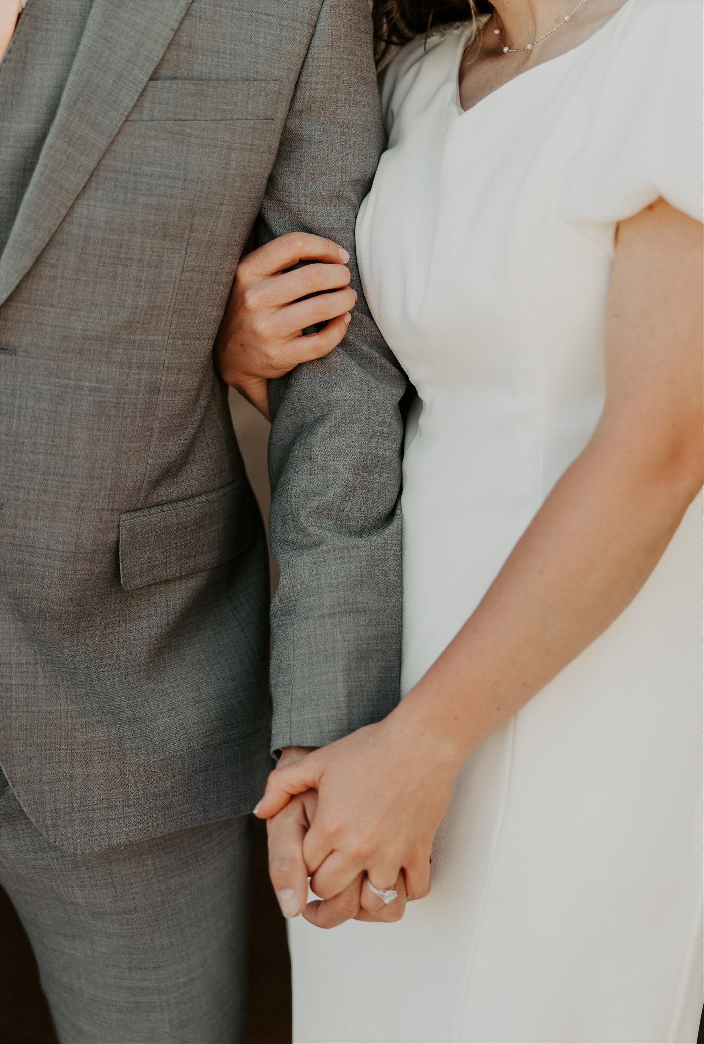 Details of newlyweds holding hands with ring during their celebration at The Icehouse wedding venue